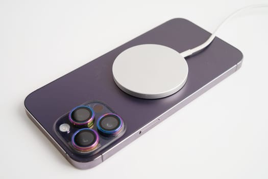 BANGKOK,THAILAND. MARCH 29 2024 MagSafe wireless magnetic charger back of iPhone 14 Pro Max, modern equipment of mobile phone.