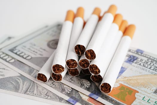Cigarette on US dollar banknotes, cost, trading, marketing and production, No smoking concept.