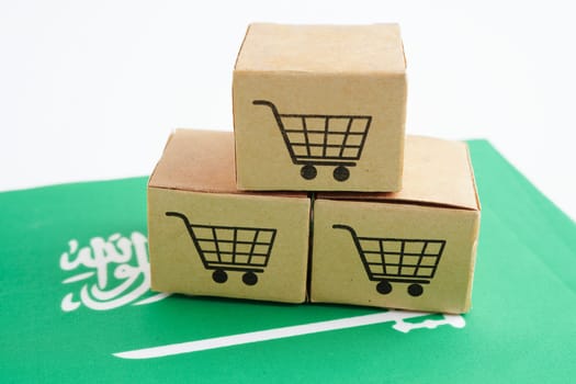 Online shopping, Shopping cart box on Saudi Arabia flag, import export, finance commerce.