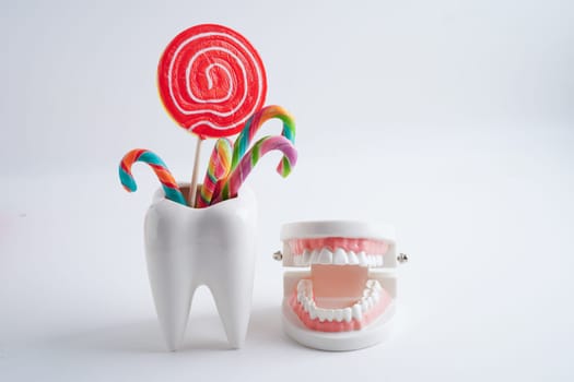 Tooth decay with sweet sugar candy, bad food for dental health care.