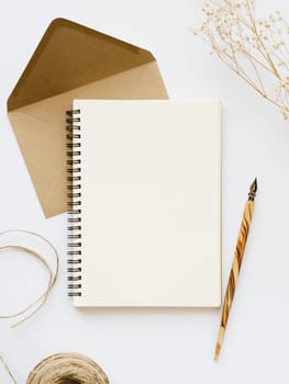 white notebook with wooden nib pale brown envelope with brown thread branch white background. Resolution and high quality beautiful photo