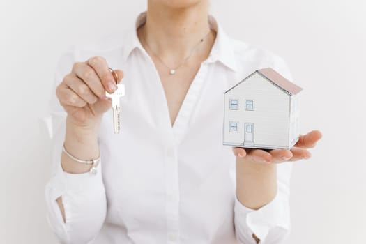 woman holding key small paper house white background. Resolution and high quality beautiful photo