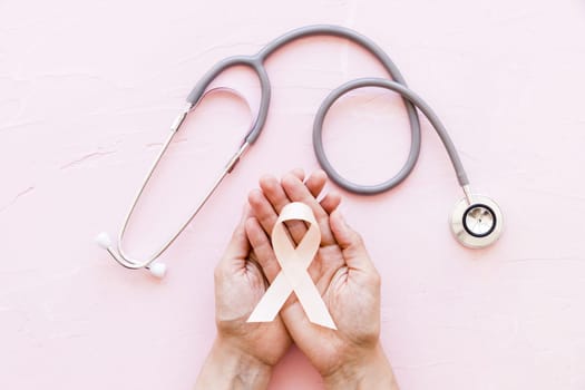 white awareness ribbon two hands with stethoscope pink background 1. Resolution and high quality beautiful photo