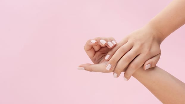 woman showing her manicure on pink background with copy space. Resolution and high quality beautiful photo
