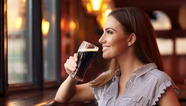 gorgeous young woman in british pub drinking beer, AI generated image
