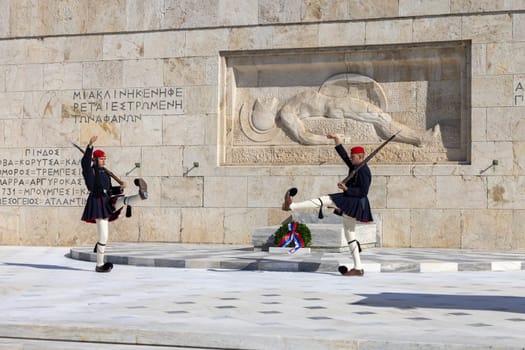 Athens, Greece - October 19, 2022: Changing of the Guard in front of Greek Parliament (Old Royal Palace) by Evzones, Greek representative military formation. On a background Tomb of Unknown Soldier.