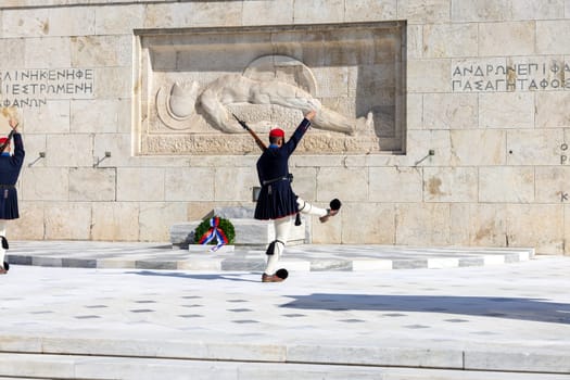 Athens, Greece - October 19, 2022: Changing of the Guard in front of Greek Parliament (Old Royal Palace) by Evzones, Greek representative military formation. On a background Tomb of Unknown Soldier.