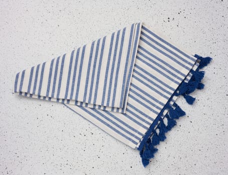 Folded linen striped kitchen towel on a white background, top view.
