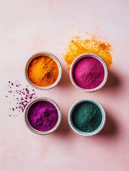 Four bowls of vibrant colorful powders on a pink background, ideal for artistic and culinary uses.