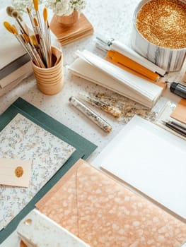 A colorful assortment of craft supplies including paper and brushes on a speckled table, perfect for artistic projects.