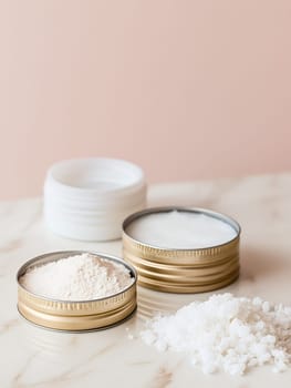 Various homemade skincare ingredients in metal tins on a marble surface, perfect for natural beauty routines.