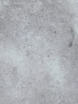 A grey and white wall with a few spots of color. The wall is made of concrete and has a rough texture