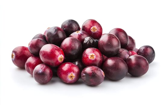 A pile of fresh cranberries on a white surface, showcasing their shiny and vibrant appearance.