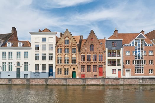 Combination of historic and modern residential buildings on the banks of a canal in the old town of Bruges in Belgium