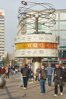 Scene with tourists and residents at the Weltzeituhr, World Time Clock in Berlin-Mitte in Germany