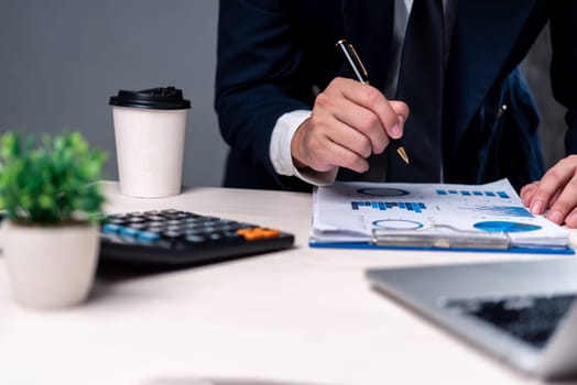 Professional analyzing financial charts and reports with a pen. Ideal for business analysis, financial planning, investment strategies, or corporate consulting visuals.
