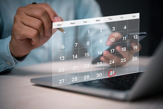Close-up of a person using a digital calendar on a laptop, highlighting the date October 31st with a red circle, indicating planning or scheduling.
