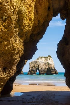Beach vertically photographed through the rock cut, near Portimao in the Algarve region of south Portugal