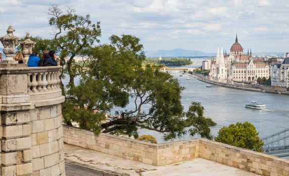 Budapest, Hungary- September 29 2024: Tourists observing the Hungarian Parliament on the banks of the Danube in Budapest, Hungary