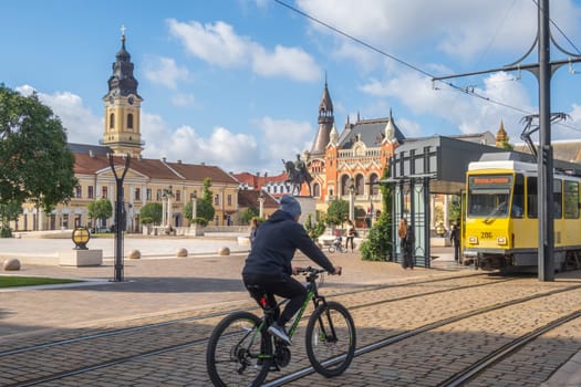 Oradea, Romania - October 07, 2024: Tram and bike on Unity Square in the old town of Oradea, Western Transylvania, Romania