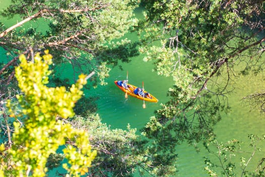 Canyon of the Tarn river, Occitanie, France - June 30 2016: Orange canoe-kayak through the trees in the gorges du Tarn