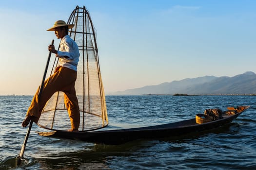 Myanmar travel attraction landmark - Traditional Burmese fisherman at Inle lake, Myanmar famous for their distinctive one legged rowing style
