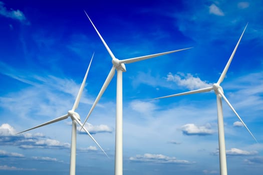 Green renewable energy concept - wind generator turbines in sky