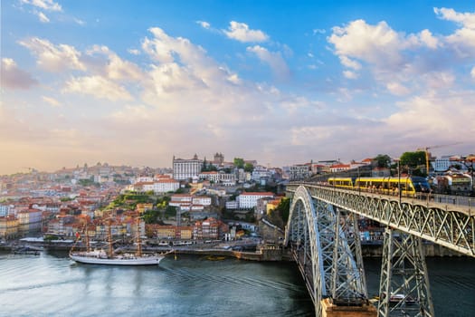 View of Porto city and Douro river and Dom Luis bridge I with tram from famous tourist viewpoint Miradouro do Jardim do Morro on sunset. Porto, Vila Nova de Gaia, Portugal
