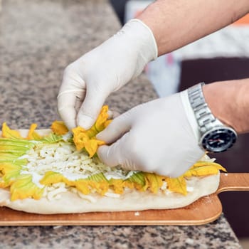 Hands of chef with white gloves making pizza. Pizza Art. The process of making pizza.