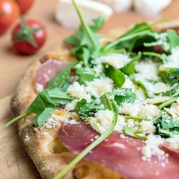 Pizza with raw ham. Close-up of a pizza with raw ham and basil.