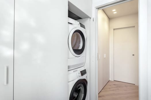 Interior of modern laundry room with washing machines and clothes dryer