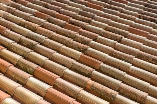 Roof tiles background. The roof tiles show their age. Seen before roofing renovation.