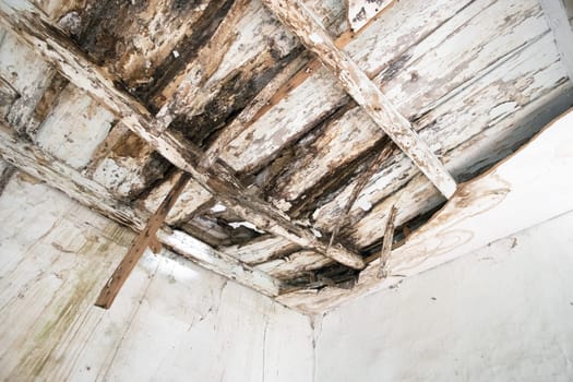 Old wooden ceiling with beams on wooden background. Needs renovation.