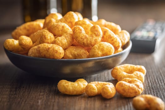 Puffed crispy Peanut flips on plate on a wooden table.