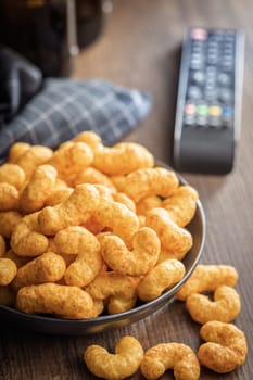 Puffed crispy Peanut flips on plate on a wooden table.