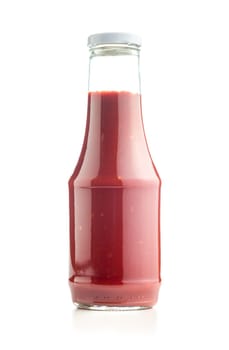 Glass bottle of ketchup isolated on a white background.