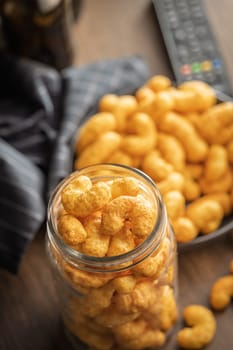 Puffed crispy Peanut flips in jar on a wooden table.