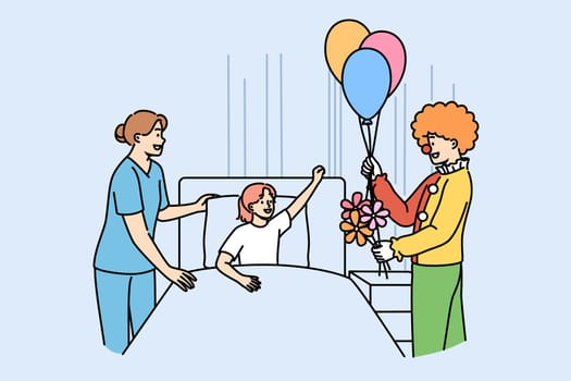 Clown entertains sick girl lying in bed in hospital to improve mood child suffering from illness. Animator gives flowers and balloons to patient at children hospital in need of psychological support