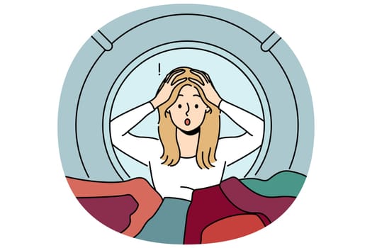 Woman peeks into washing machine and grabs head after seeing ruined clothes due to non-compliance with rules of use. Shocked housewife gets stressed, learning about washing machine breakdown