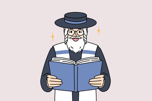 Old jewish man reads torah, studying gospel or prayers for shabbat visit to synagogue. Orthodox jewish in hat and blue and white vest in process of worship during holiday celebration of hanukkah