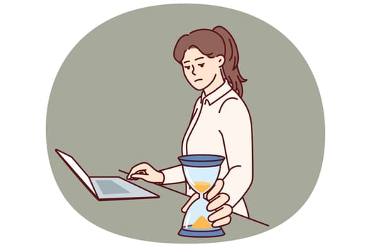 Busy businesswoman with hourglass keeps track of time until deadline so as not to violate terms of important contract. Freelancer girl in business suit stands near laptop and does time management