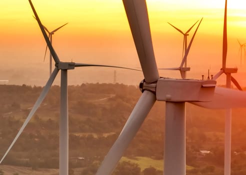 Wind farm field and sunset sky. Wind power. Sustainable, renewable energy. Wind turbines generate electricity. Sustainable development. Green technology for energy sustainability. Eco-friendly energy.