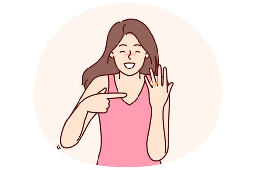 Happy bride with wedding ring shows off gift from groom and rejoices at proposal to get married. Woman with smile demonstrates wedding ring on finger for concept of successful marriage