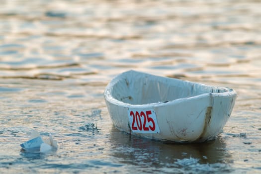 A small white boat marked with 2025 drifts gently on the calm water under soft golden light creating a serene atmosphere.