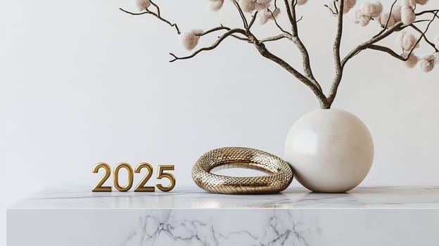 A stylish arrangement features the year 2025, a gold bracelet, and a vase with cotton branches on a marble table.