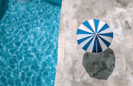 A refreshing poolside view features a blue water surface and a striped umbrella, inviting relaxation and coolness on a warm day.