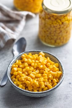 Canned sweet corn in bowl on a kitchen table.