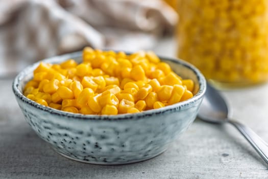 Canned sweet corn in bowl on a kitchen table.