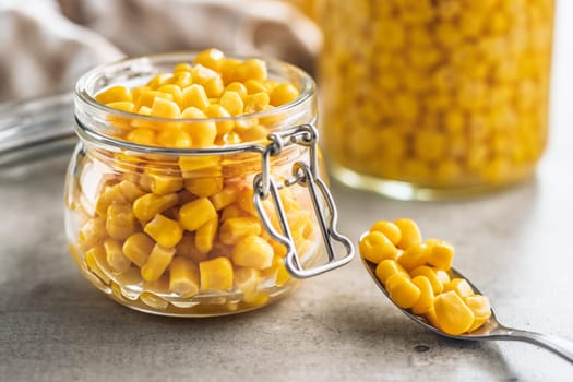 Canned sweet corn in jar on a kitchen table.