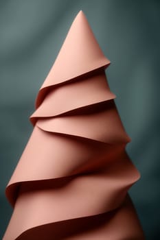 A creatively designed tree made from layered paper in a soft hue, showcasing an artistic approach to holiday decor.
